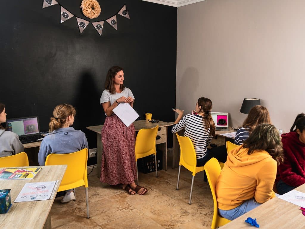 Teacher guiding students through a coding lesson