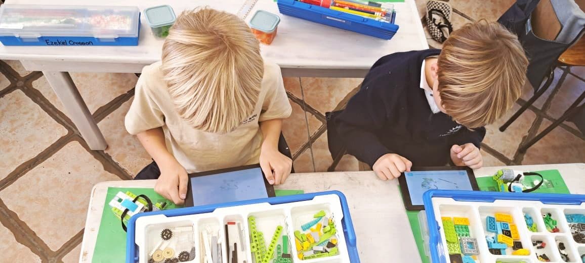 Boys collaborating on building a Makerzoid robotics kit
