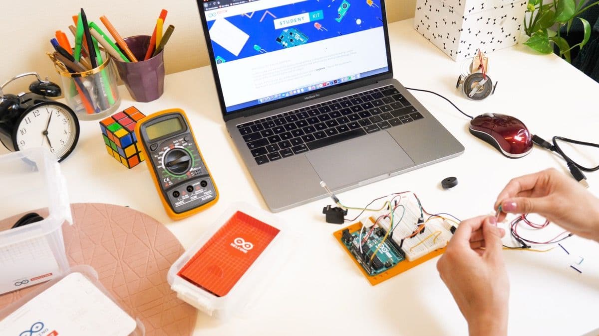 Student connecting up the Arduino Student Kit with a laptop in front