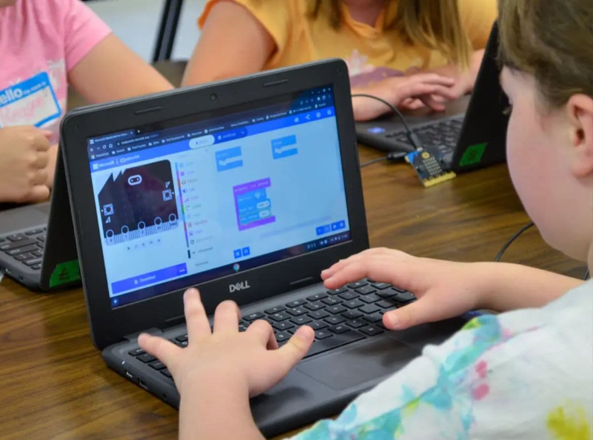 Child working on a computer with the micro:bit coding application