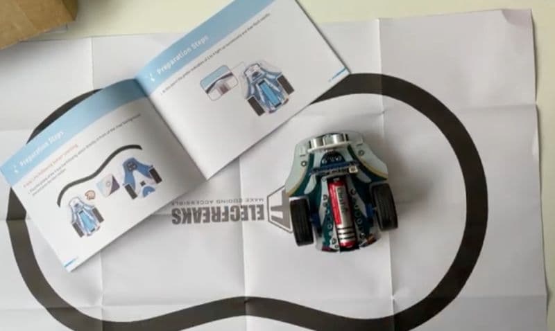 Cutebot Pro on a line-following track map with the user manual beside it