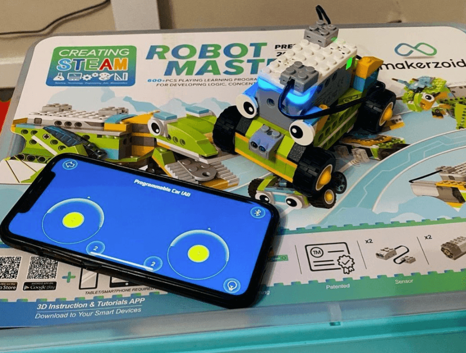 Makerzoid car build on box with app open on phone