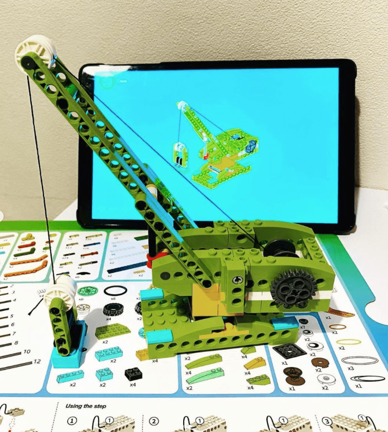 Makerzoid crane build sitting on box with tablet behind