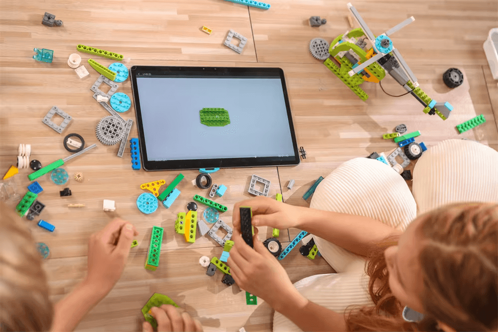 Kids building with Makerzoid pieces following tablet instructions