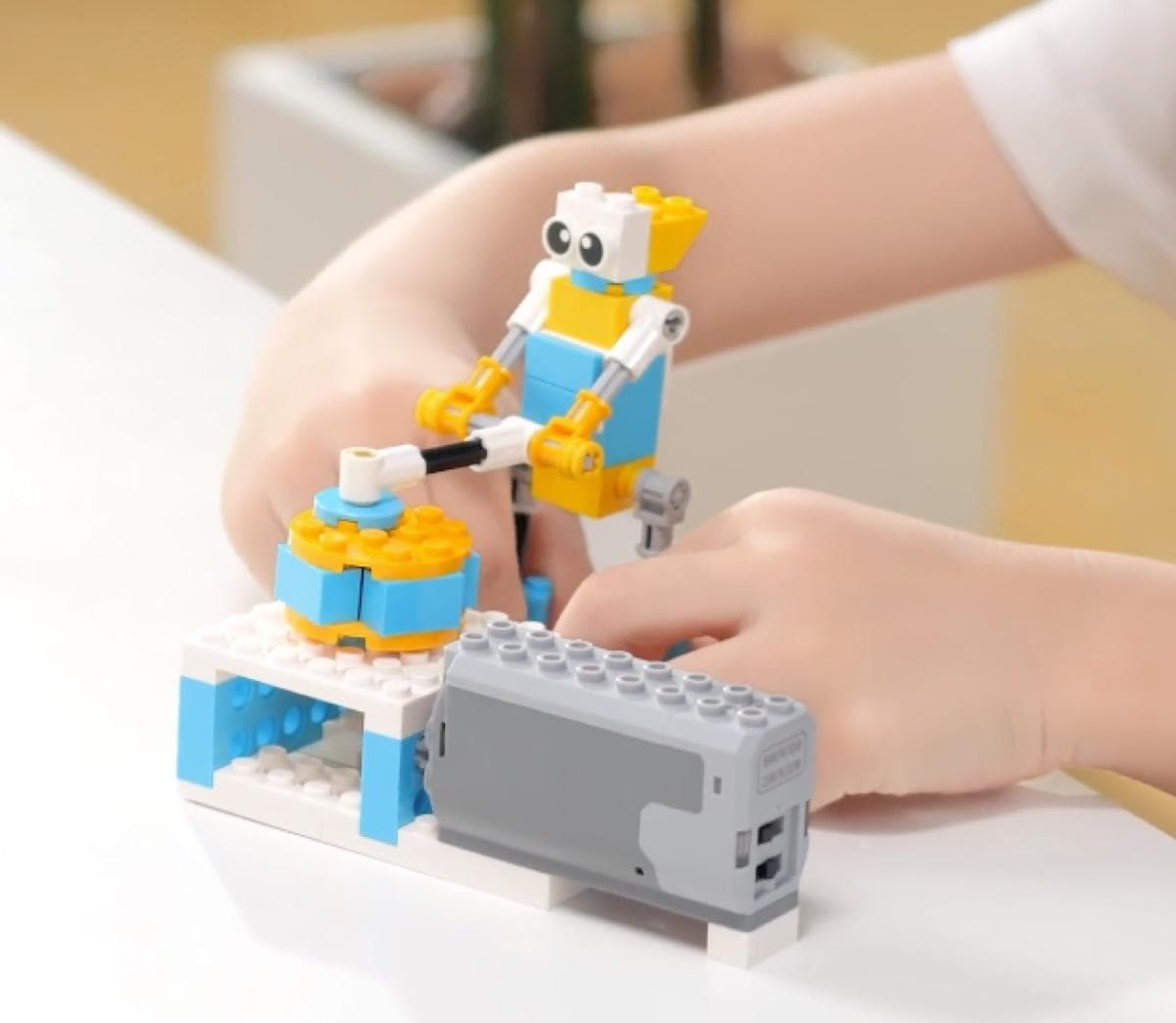 Child's hands proudly holding a completed robot build