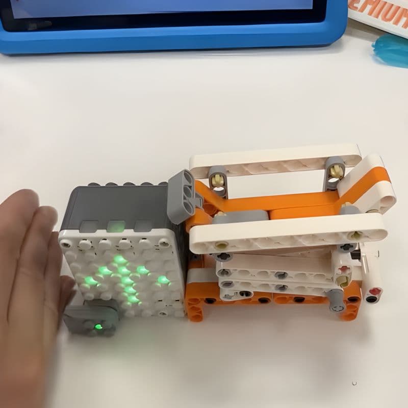 Child testing the distance sensor on an assembled Makerzoid Superbot