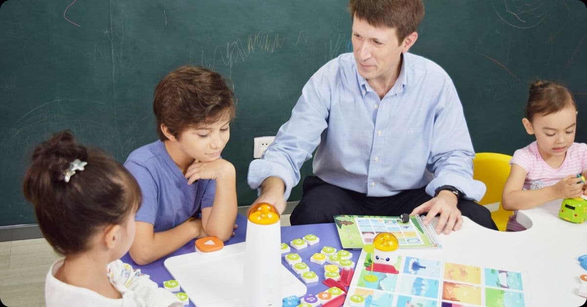 Teacher explaining coding concepts to young learners in a Foundation Phase classroom