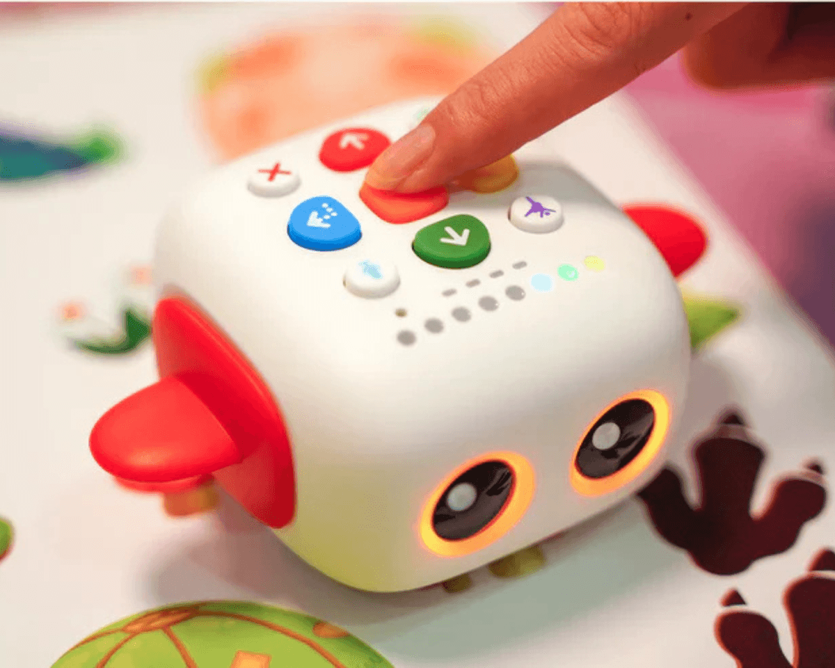 Child's finger pressing command button on Tale-Bot Pro robot