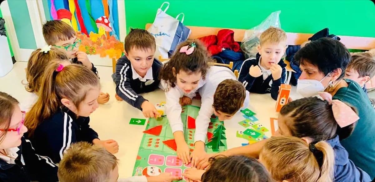 Large group of young learners gathered around Tale-Bot Pro robots in a classroom