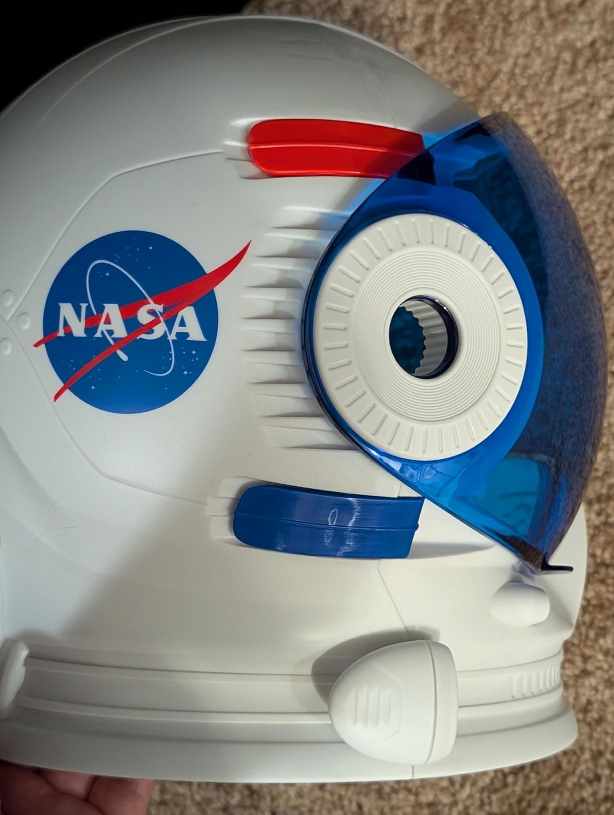 Close-up of the NASA meatball logo on the helmet with visor open