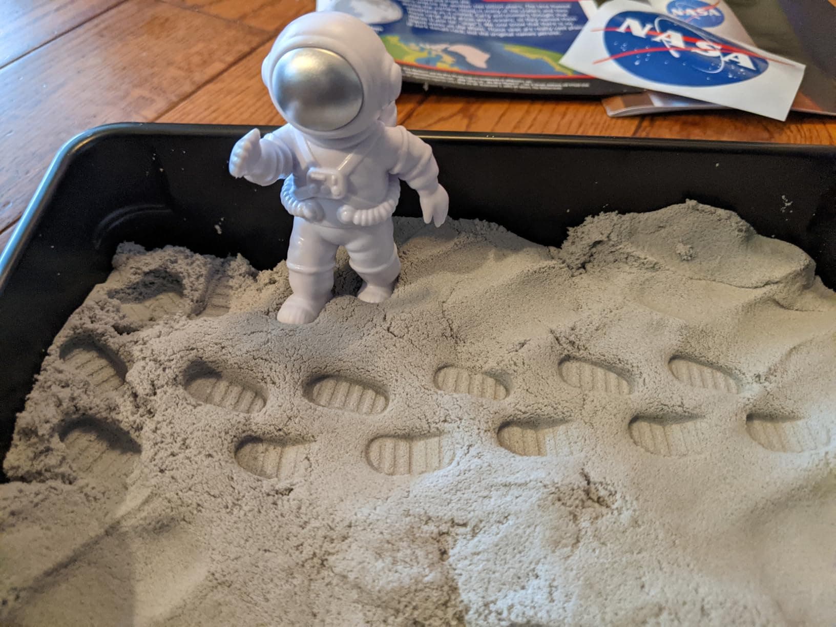 Astronaut figure leaving footprints in the moon sand