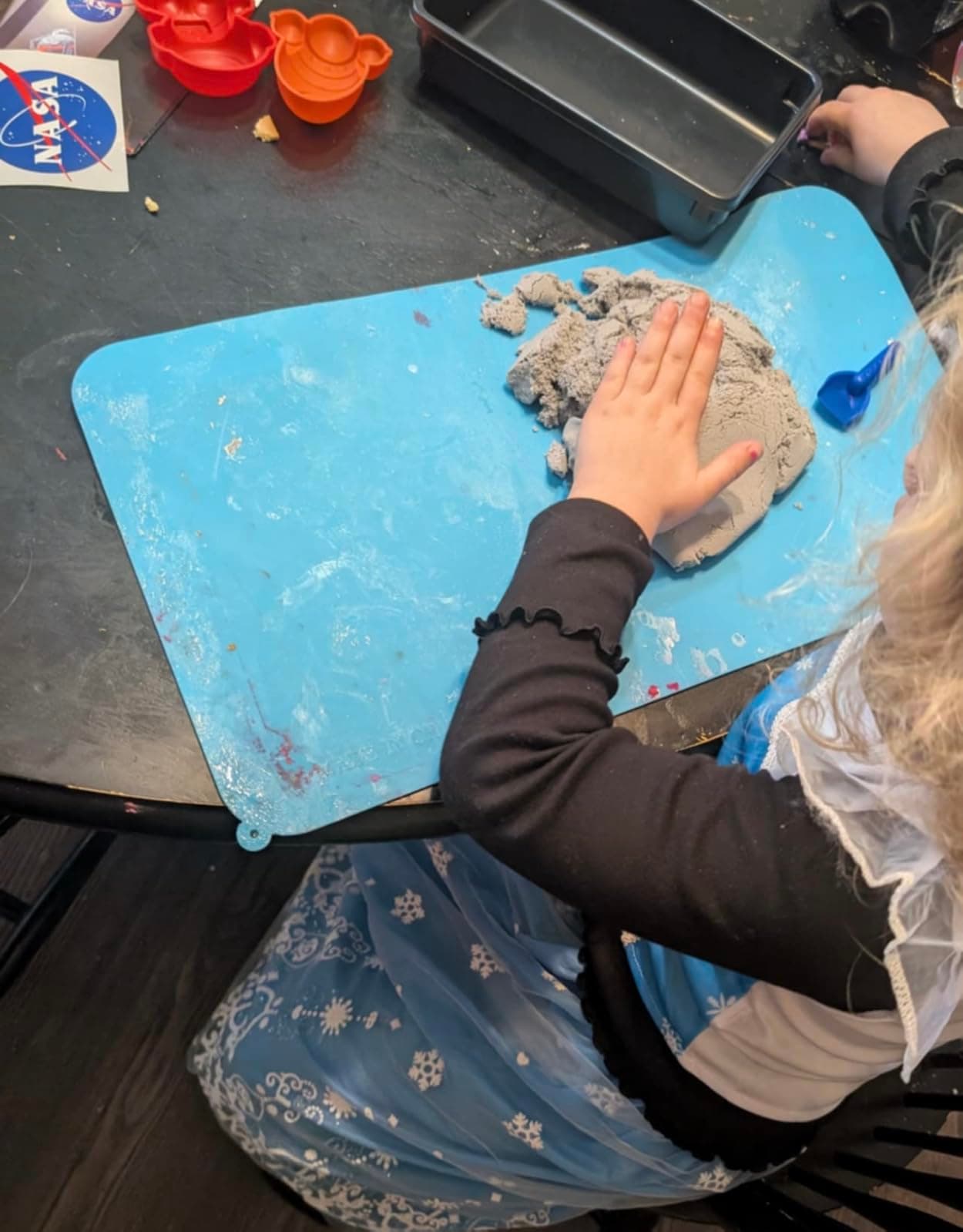Child playing with the NASA Moon Sand activity kit