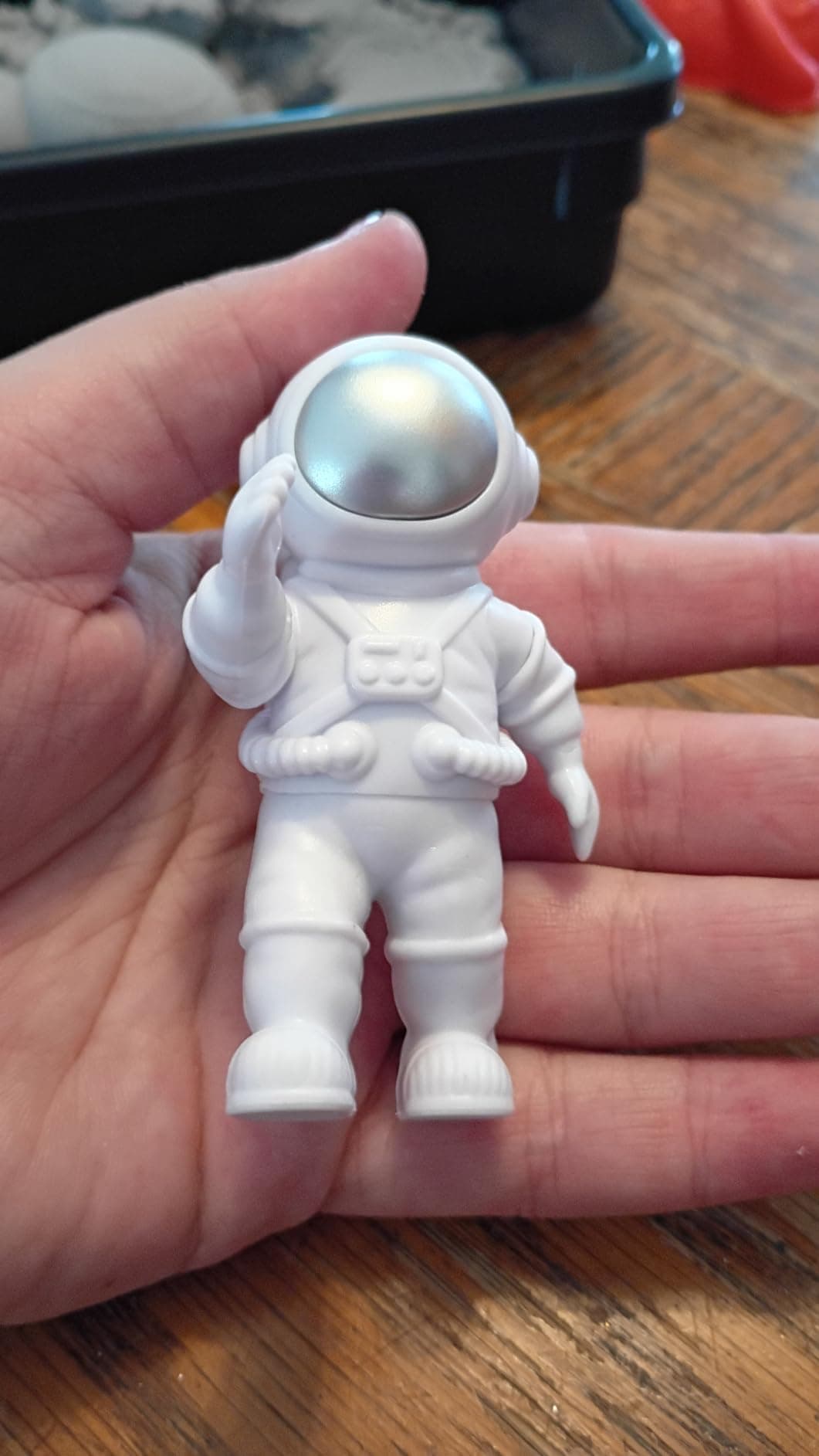 Child's hand holding the astronaut figure