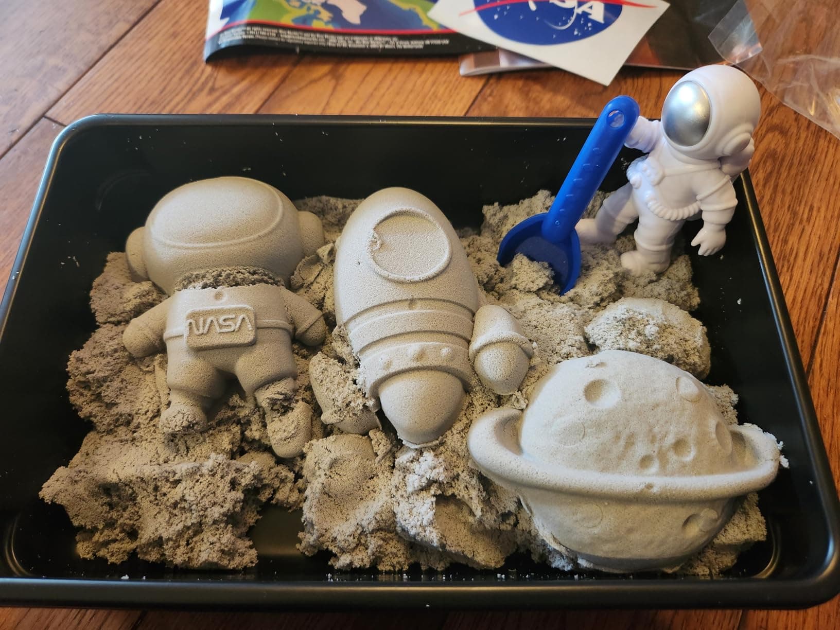 Play tray filled with moon sand and shaped mold creations