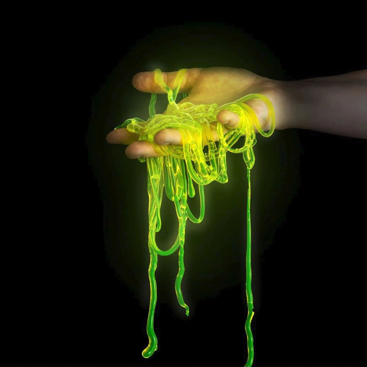 Hand holding glowing polymer worms made in a chemistry experiment