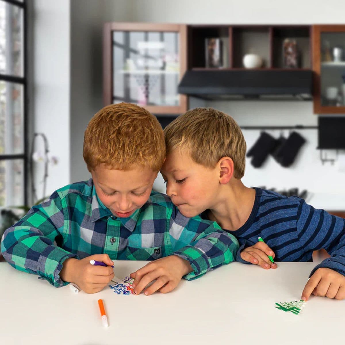 Boy colouring in a cardboard tree with washable markers