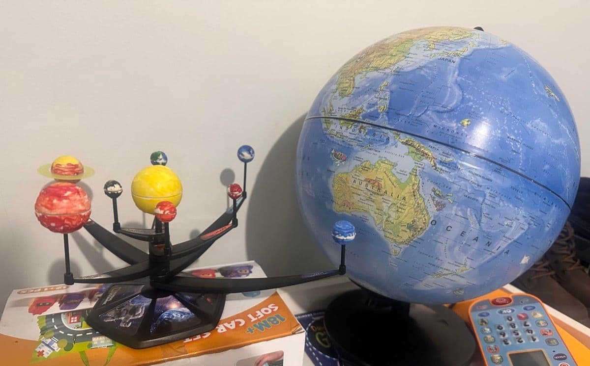 Completed solar system model displayed next to a globe