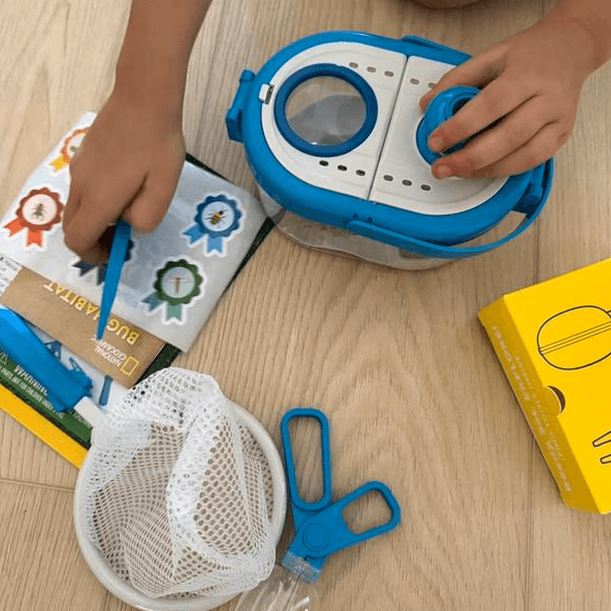 Child sitting on floor exploring the unboxed kit contents
