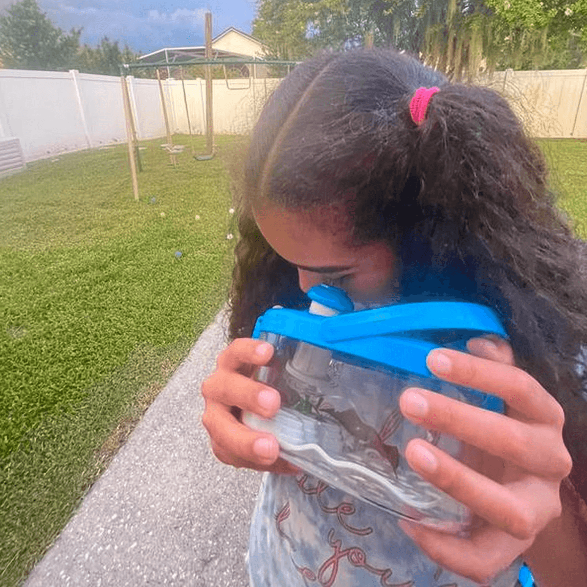 Girl in garden looking through magnifying glass at insects