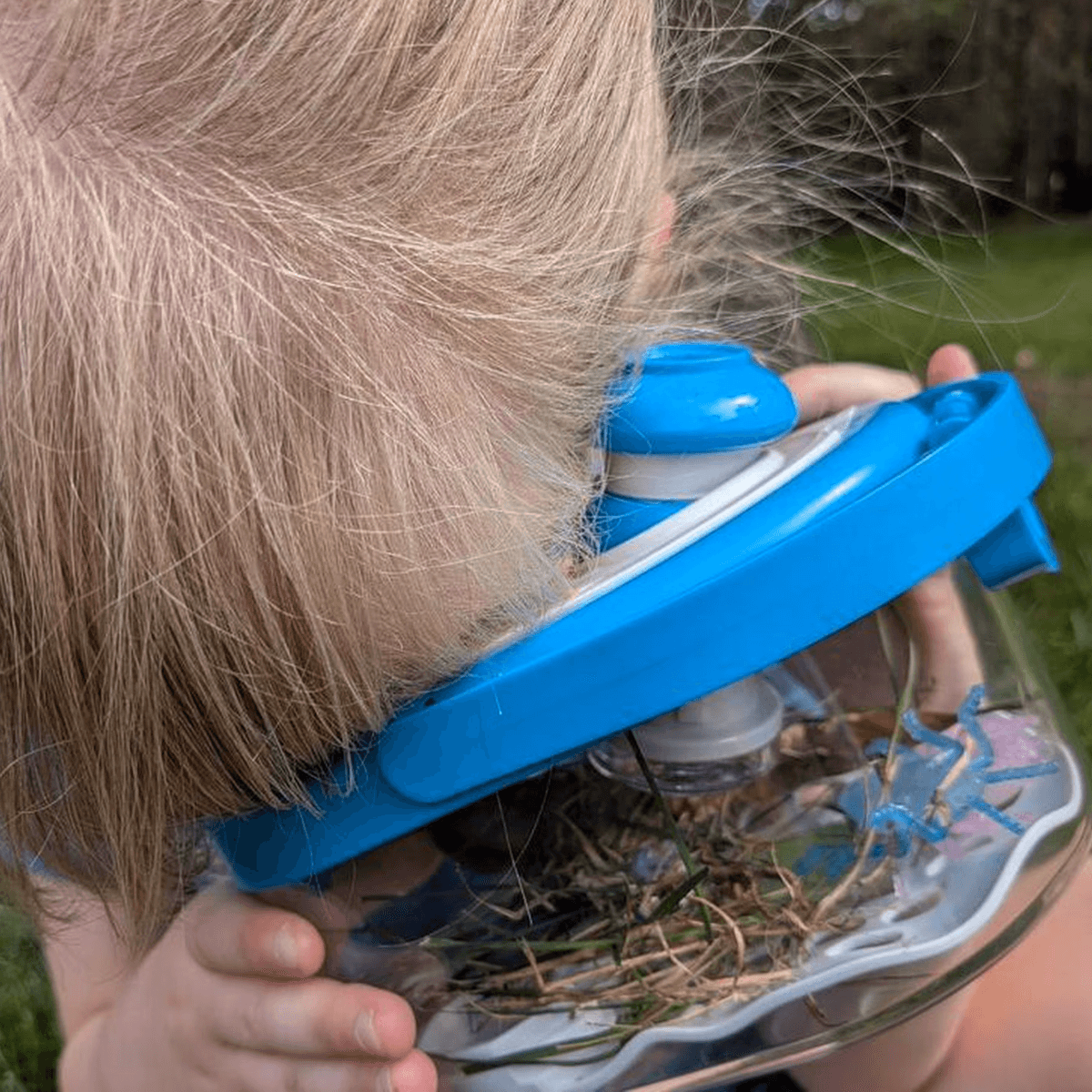 Girl looking closely through the habitat magnifying glass