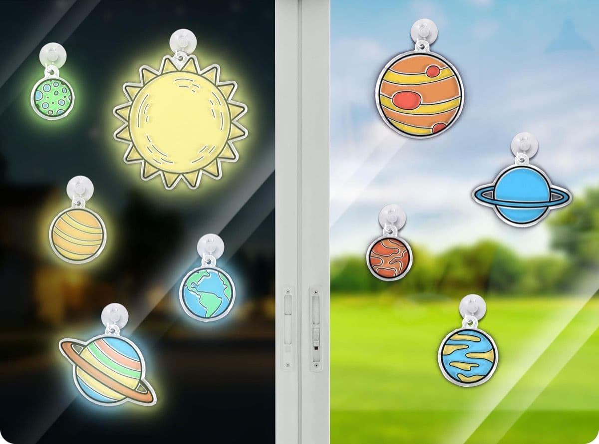 Side-by-side comparison of the solar system window display in daylight and glowing in the dark