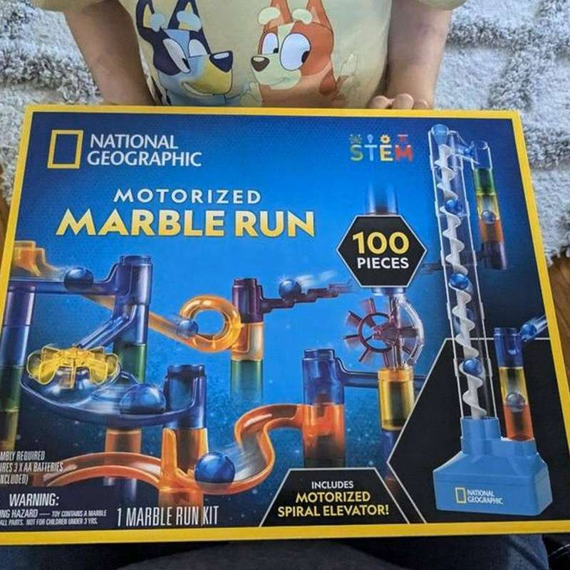 Child holding the National Geographic Motorized Marble Run box