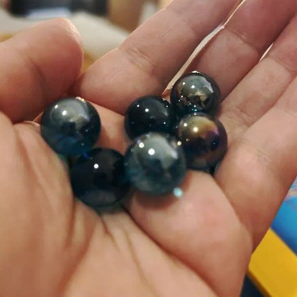 Hand holding a selection of the 15 marbles included in the kit
