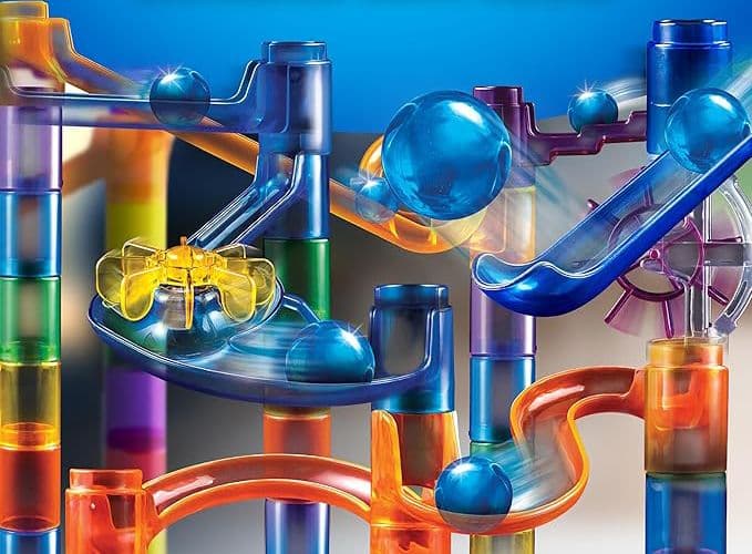 Close-up of marbles travelling through the clear tube track of the marble run