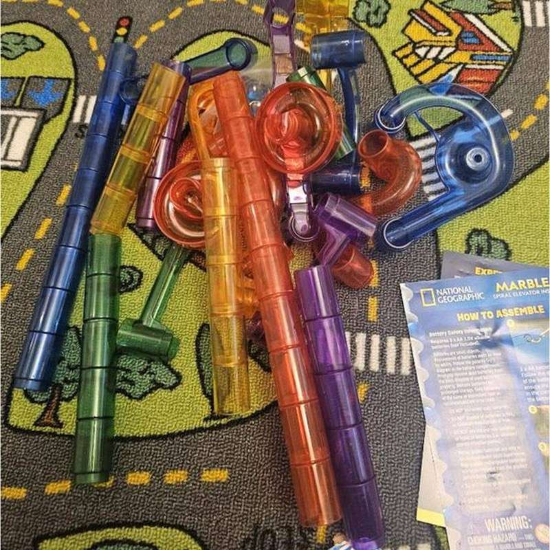 All 75 pieces of the National Geographic Motorized Marble Run laid out on a mat