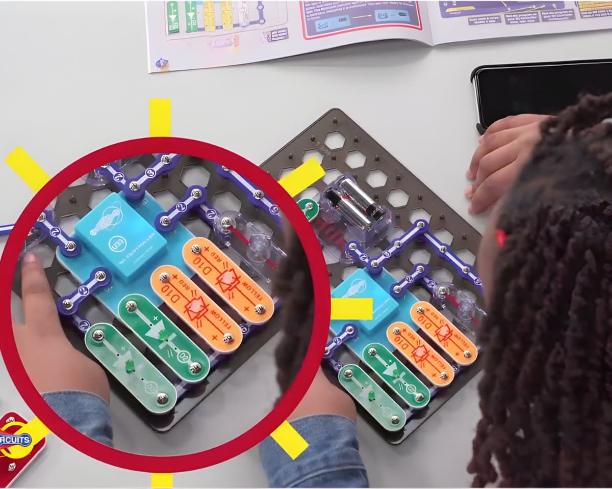 Close-up of child's hands snapping circuit pieces together