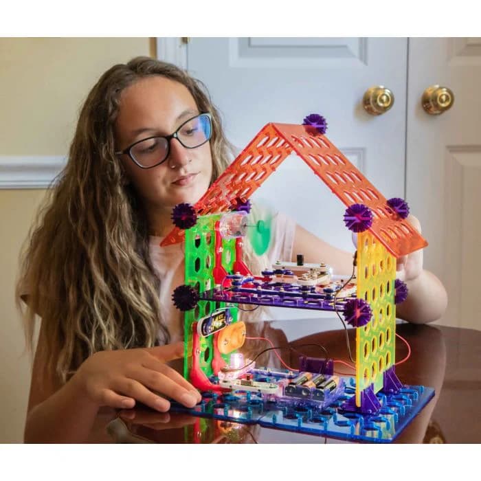Girl focused on building with Snap Circuits My Home